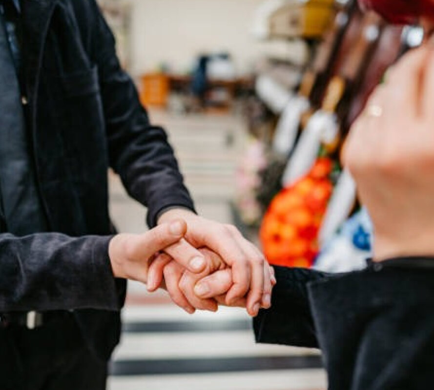 Три человека держатся за руки в магазине