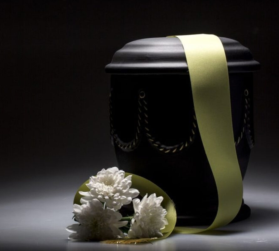 Ваза с прахом на черном фоне и три белых цветка